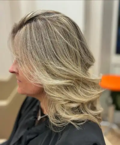 Balayage blond brushing ondulé cheveux mi-longs